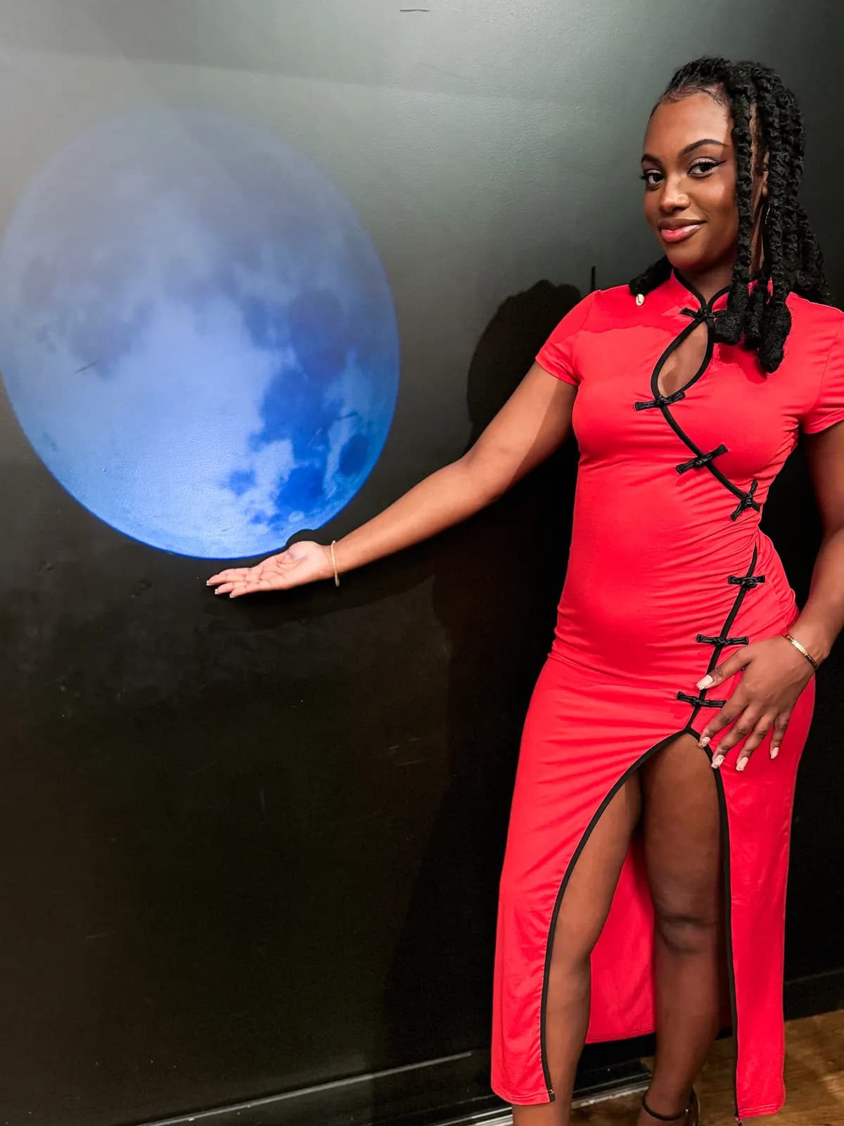 Invitée en robe rouge devant le décor lunaire de la soirée